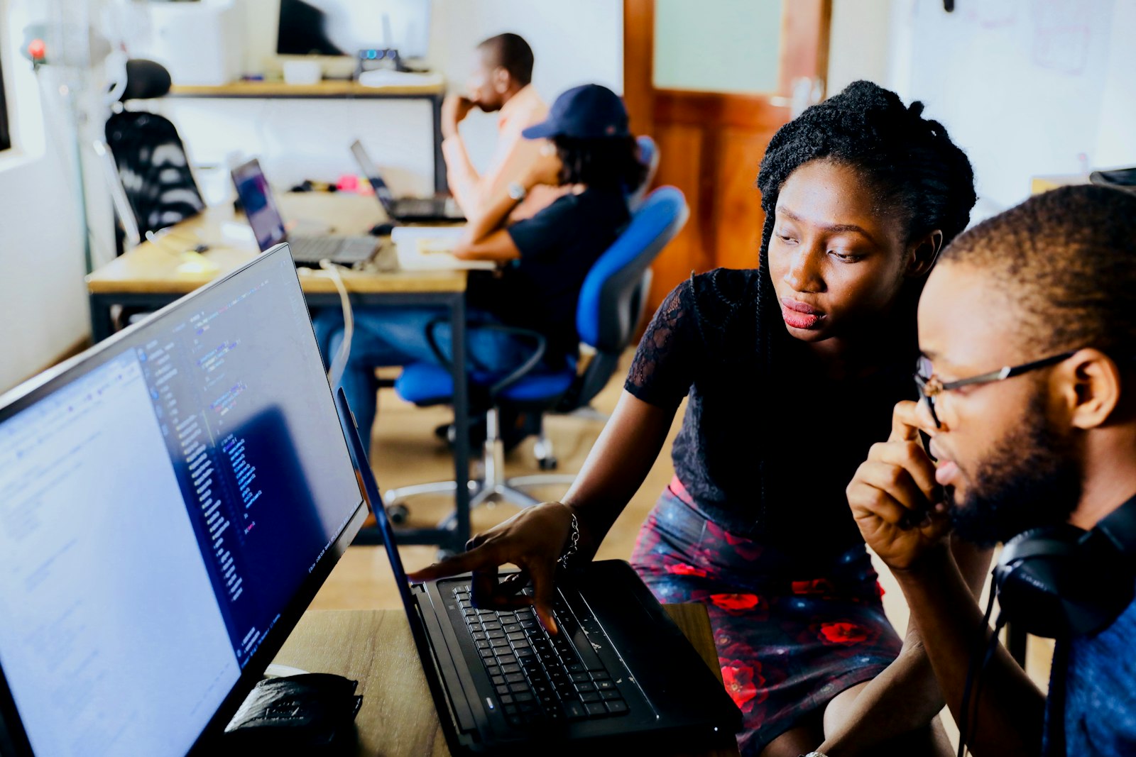 People learning together around laptops in a workshop