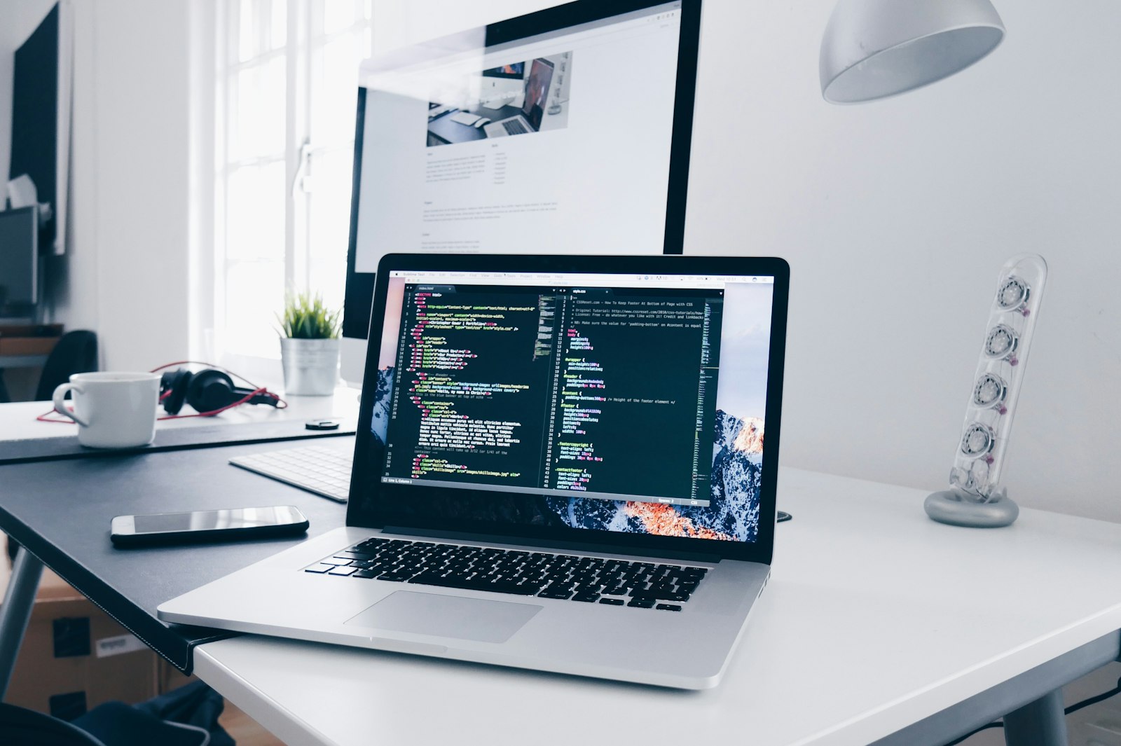 A laptop showing code in a dim workspace